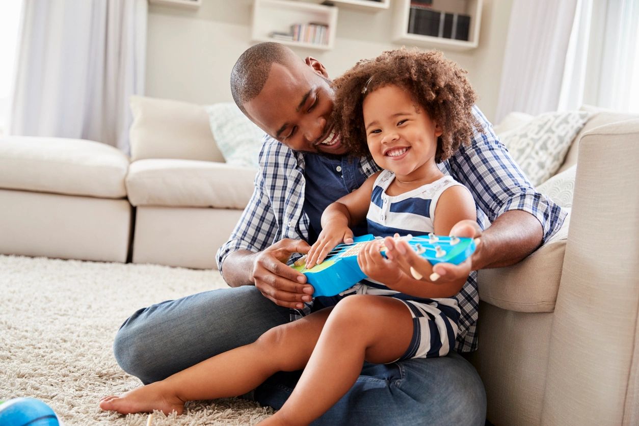 Father and daughter reading together in a warm living room